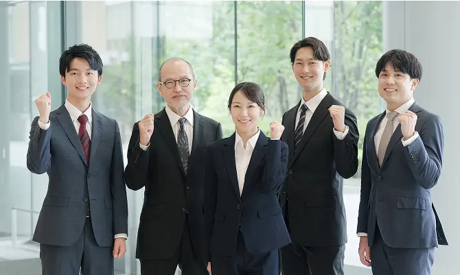 スーツ姿の社員が並ぶ、大手事例会社D社の集合写真