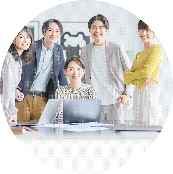 オフィスで笑顔の5人の男女スタッフが並んでポーズをとっている様子